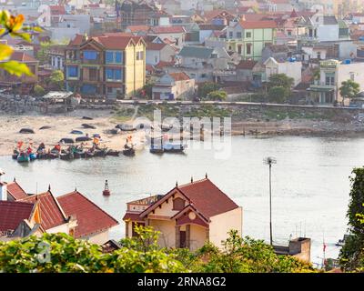 Hai Binh, un villaggio di pescatori lungo il fiume Song Lach Bang nella provincia di Thanh Hoa in Vietnam. Le barche in primo piano sono luminose, mentre la V Foto Stock