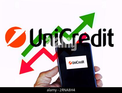 August 25th 2023. Florence , Italy , person holding a smart phone while trading in the stock market for UniCredit . Concept of price going up and down Stock Photo