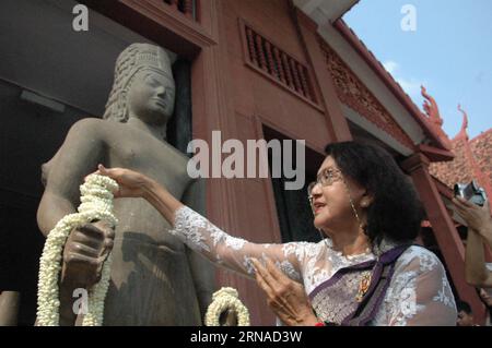 (160121) -- PHNOM PENH, Jan. 21, 2016 -- A woman lays flowers on a reattached Harihara statue at the National Museum in Phnom Penh, Cambodia, Jan. 21, 2016. A 47-kilogram head of the Harihara statue, a deity that combines aspects of the Vishnu and Shiva gods, was reattached to its life-sized body and exhibited to the public at the National Museum in Phnom Penh on Thursday. France s Guimet Museum returned the head of the statue that was taken from a Cambodian temple 130 years ago to Cambodia on Tuesday. Sovannara) CAMBODIA-PHNOM PENH-STATUE HEAD-REATTACHMENT Phearum PUBLICATIONxNOTxINxCHN   160 Stock Photo