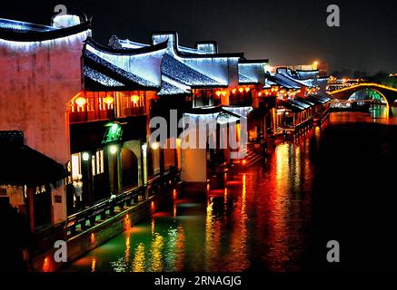 (160125) -- PECHINO, 25 gennaio 2016 -- foto scattata il 16 aprile 2010 mostra lanterne appese a case lungo un fiume nella città di Jiaxing, nella provincia dello Zhejiang nella Cina orientale. Le lanterne in Cina hanno una lunga storia e sono diventate sinonimo di cultura cinese. Ancora oggi, sono ancora fatti e apprezzati dai cinesi in tutto il mondo. Sono stati usati come mezzo di espressione artistica, in termini di funzionalità, design e decorazione. Le strade cinesi di entrambe le città sono decorate con lanterne rosse durante i festival, in particolare Capodanno lunare cinese, Festival di metà autunno e Festival delle Lanterne. ) (zkr) Foto Stock