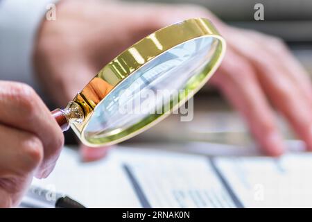 Verifica delle imposte con lente di ingrandimento sul documento di fattura Foto Stock