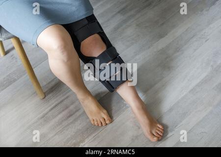 Primo piano della gamba femminile con ginocchiera. Ortopedic Anatomic Orthosis (Ortopedic Anatomic Orthosis). Apparecchi per fissaggio al ginocchio, lesioni e dolore. Tutor di ortosi del piede Foto Stock