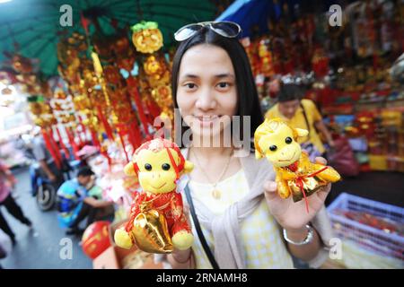 (160201) -- BANGKOK, Feb. 1, 2016 -- A Thai woman shows monkey dolls in front of a decoration shop at China Town in Bangkok, Thailand, Feb. 1, 2016. The Chinese lunar calendar assigns an animal symbol to each year in a 12-year cycle. According to the zodiac, 2016 is the Year of the Monkey starting from Feb. 8. )(dh) THAILAND-BANGKOK-CHINA TOWN-NEW YEAR DECORATIONS RachenxSageamsak PUBLICATIONxNOTxINxCHN   Bangkok Feb 1 2016 a Thai Woman Shows Monkey Dolls in Front of a Decoration Shop AT China Town in Bangkok Thai country Feb 1 2016 The Chinese Lunar Calendar assigns to Animal symbol to each Y Foto Stock