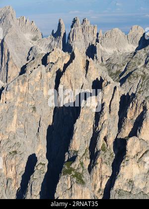 VISTA AEREA. Il frastagliato massiccio orientale del Catinaccio nelle Dolomiti con le Torri Vajolet (2821 m) in lontananza. Trentino-alto Adige, Italia. Foto Stock