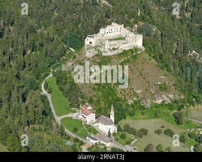 VISTA AEREA. Castello di Montechiaro o Schloss Lichtenberg (in tedesco) affacciato su una chiesa parrocchiale. Trentino-alto Adige, Italia. Foto Stock