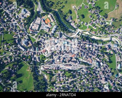 VISTA AEREA VERTICALE. Il centro di Cortina d'Ampezzo sulla riva sinistra del fiume Boite. Provincia di Belluno, Veneto, Italia. Foto Stock