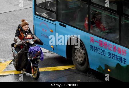 (160308) -- HANGZHOU, March 8, 2016 -- A woman rides on the street with her child in Hangzhou, capital of east China s Zhejiang Province, March 8, 2016. Hangzhou Meteorological Observatory issued a blue warning signal for cold wave Tuesday. ) (yxb) CHINA-HANGZHOU-WEATHER(CN) ShixJianxue PUBLICATIONxNOTxINxCHN   Hangzhou March 8 2016 a Woman Rides ON The Street With her Child in Hangzhou Capital of East China S Zhejiang Province March 8 2016 Hangzhou Meteorological Observatory issued a Blue Warning Signal for Cold Wave Tuesday yxb China Hangzhou Weather CN ShixJianxue PUBLICATIONxNOTxINxCHN Stock Photo