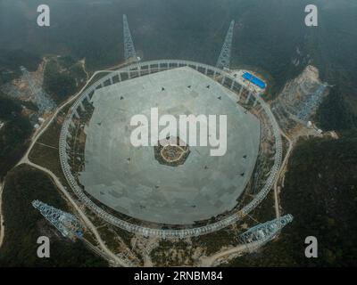 (160309) -- PINGTANG, March 9, 2016 -- Photo taken on March 9, 2016 shows an aerial view of the assembly site of the single-aperture spherical telescope FAST in Pingtang County, southwest China s Guizhou Province. A total of 3,492 reflector panels, an equilateral triangle with a side length of 11 meters each, have been installed on the frame. When it is completed in 2016, the five hundred meter aperture spherical telescope (FAST) will be the world s largest, overtaking Puerto Rico s Arecibo Observatory, which is 300 meters in diameter. ) (zkr) CHINA-GUIZHOU-RADIO TELESCOPE FAST-INSTALLATION (C Stock Photo