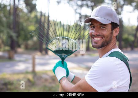 homeowner raking up dead fallen leaves Stock Photo