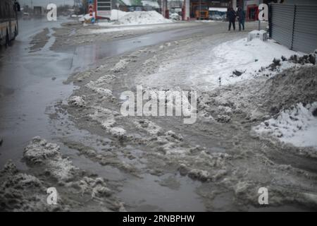 Melted snow on road. Large puddle in spring. Lots of water on asphalt. Stock Photo