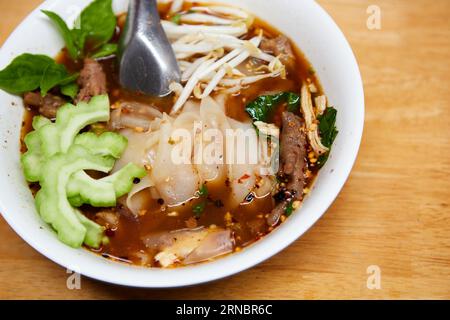Spaghetti di riso larghi con carne di pollo brasata in un recipiente Foto Stock