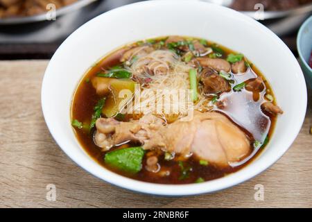 Rice vermicelli noodles with braised chicken meat in a bowl Foto Stock