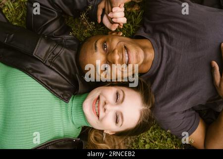 Direttamente sopra la vista di una giovane donna felice e di un uomo sdraiato sull'erba Foto Stock