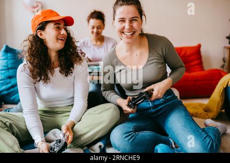 Amiche felici che giocano ai videogame a casa Foto Stock