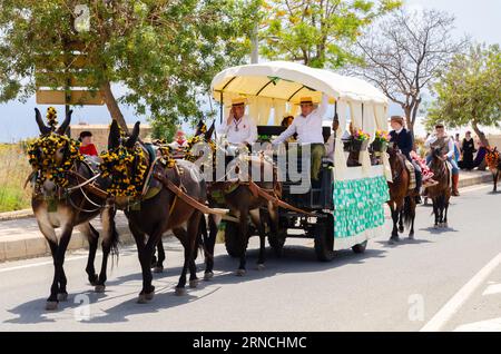 NERJA, SPAGNA - 15 MAGGIO 2022 abitanti della città, carrozze, carri, cavalli, buoi e trattori, così come gli agricoltori locali provenienti dai villaggi vicini Foto Stock