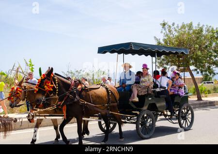 NERJA, SPAGNA - 15 MAGGIO 2022 abitanti della città, carrozze, carri, cavalli, buoi e trattori, così come gli agricoltori locali provenienti dai villaggi vicini Foto Stock