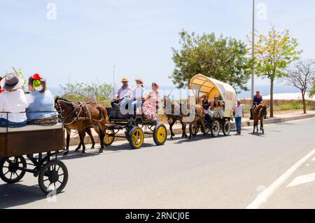 NERJA, SPAGNA - 15 MAGGIO 2022 abitanti della città, carrozze, carri, cavalli, buoi e trattori, così come gli agricoltori locali provenienti dai villaggi vicini Foto Stock