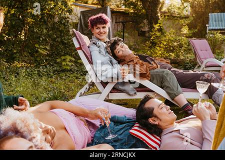 Amici felici della comunità LGBTQ durante la cena in cortile Foto Stock