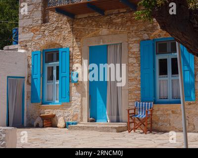 Graziosi dettagli di finestre, porte e balconi di una vecchia casa sull'isola di Simi. Vacanze nelle isole della Grecia da Rodi nel Mar Egeo. Colorato stile neoclassico Foto Stock