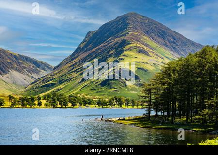 Nuota su un grande e tranquillo lago circondato da montagne in una calda giornata estiva Foto Stock