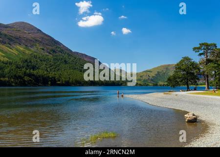 Nuota su un grande e tranquillo lago circondato da montagne in una calda giornata estiva Foto Stock