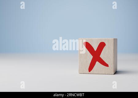 Croce x sul cubo di legno. Cartello di rifiuto nella pila di cubi di legno. Concetto di decisione negativa o scelta di voto, againt, resistere, contravene la Foto Stock