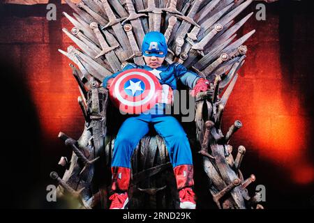 (160429) -- BANGKOK, 29 aprile 2016 -- Un ragazzo in costume da capitano americano posa per una foto mentre siede sul Trono di ferro della serie di romanzi fantasy A Song of Ice and Fire durante il Bangkok Comic con del 2016 a Bangkok, Thailandia, 29 aprile 2016. I fan del fumetto e dell'animazione in Thailandia si sono riuniti venerdì al Bangkok International Trade & Exhibition Center per l'apertura del Bangkok Comic con 2016. Durante i tre giorni di combo, i visitatori saranno raggiunti da oltre cinquanta espositori internazionali del settore, tra cui Marvel, HBO e Bandai, con i loro ultimi prodotti e vari interactiv Foto Stock