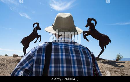 (160502) -- LOS ANGELES, May 2, 2016 -- A visitor watches two steel welded antelopes are seen in the desert of Borrego Springs, Los Angeles, the United States on May 2, 2016. Dennis Avery, a late philanthropist of Borrego Springs, envisioned the idea of adding Sky Art to his property with original steel welded sculptures created by artist Ricardo Breceda based in Perris, California. Besides a 350-foot-long fanciful serpent, visitors can see over 130 metal sculptures installed in the desert of Borrego Springs. ) U.S.-LOS ANGELES-BORREGO SPRINGS-SKY ART-SCULPTURE YangxLei PUBLICATIONxNOTxINxCHN Stock Photo