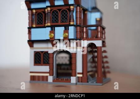 lego borgo medievale mercato 1601, Una persona sta costruendo una casa lego, villaggio lego allestito al mattino sul tavolo. Foto Stock