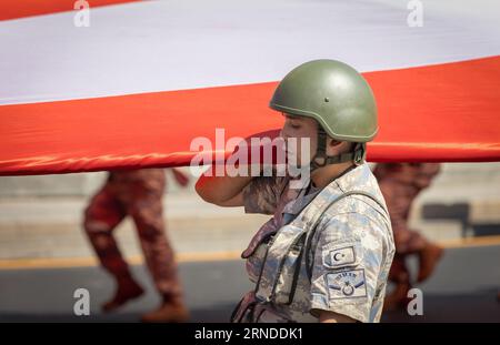 Ankara-Turchia: 30 agosto 2023: Foto ravvicinata di uno dei soldati turchi che trasportano una gigantesca bandiera turca e marciano durante il 30 agosto, giorno della Vittoria Foto Stock