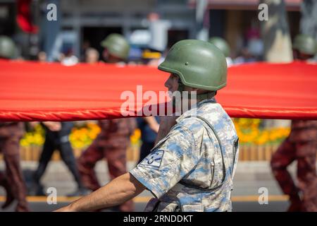 Ankara-Turchia: 30 agosto 2023: Foto ravvicinata di uno dei soldati turchi che trasportano una gigantesca bandiera turca e marciano durante il 30 agosto, giorno della Vittoria Foto Stock