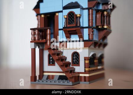 lego borgo medievale mercato 1601, Una persona sta costruendo una casa lego, villaggio lego allestito al mattino sul tavolo. Foto Stock