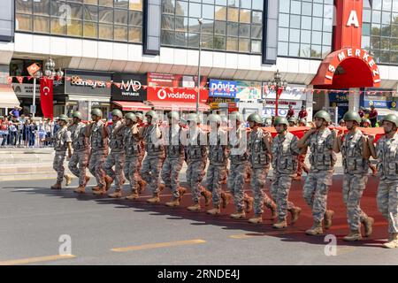 Ankara-Turchia: 30 agosto 2023: Gruppo di soldati turchi che trasportano una gigantesca bandiera turca e marciano durante il 30 agosto, parata del giorno della Vittoria ad Ankara. Foto Stock