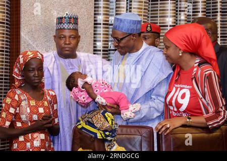 (160519) -- ABUJA, 19 maggio 2016 -- il presidente nigeriano Muhammadu Buhari (2nd-R) tiene il bambino della studentessa di Chibok salvata, Amina Ali-Nkeki (L), durante un incontro presso la villa presidenziale nella capitale Abuja, Nigeria, 19 maggio 2016. Giovedì il presidente nigeriano Muhammadu Buhari ha incontrato la studentessa salvata Chibok, Amina Ali-Nkeki, e il bambino di mesi, sua madre e suo fratello. Ali-Nkeki è stata la prima ragazza Chibok ad essere salvata dalle autorità nigeriane. Un totale di 276 ragazze sono state rapite dai militanti di Boko Haram dai loro dormitori della scuola secondaria nella città di Chibok, nel nord-est del B Foto Stock