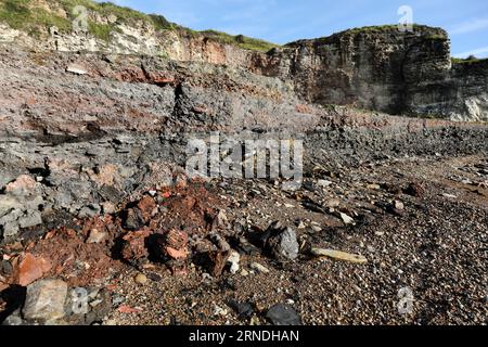 Strati di miniere di carbone e rifiuti di altoforni insieme ad altri detriti industriali che vengono lentamente erosi e lavati via dal mare sulla Blast Bea Foto Stock