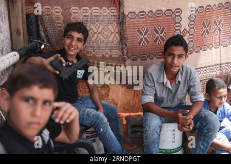 (160527) -- GAZA, 27 maggio 2016 -- il bambino palestinese Ibrahim al-Nemnem (2° R), 13 anni, è visto seduto con i suoi amici fuori dalla sua casa nel campo profughi Shati nella città di Gaza, il 22 maggio 2016. Al-Nemnem, cresciuto tra gli stretti vicoli del campo profughi di Shati, sogna di essere un ingegnere per contribuire allo sviluppo del campo e migliorare la vita dei suoi abitanti. Mentre il mondo osserva la giornata internazionale per la protezione dei bambini il 1° giugno, al-Nemnem e i suoi coetanei occupano le loro giovani menti con grandi sogni di una vita migliore, più sicura e più stabile in uno dei più duri e duri Foto Stock