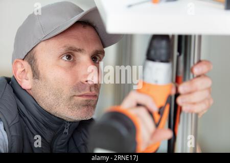 vista ravvicinata del tuttofare utilizzando un trapano cordless Foto Stock