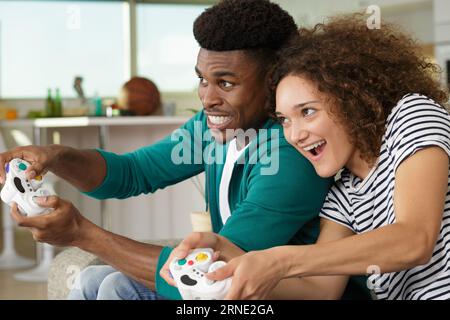 excited couple playing computer game in the home Foto Stock