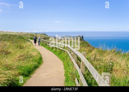 Scogliere di Bempton due persone camminano lungo il sentiero in cima alla scogliera presso la riserva RSPB Bempton East Riding della costa dello Yorkshire Inghilterra regno unito gb Europa Foto Stock