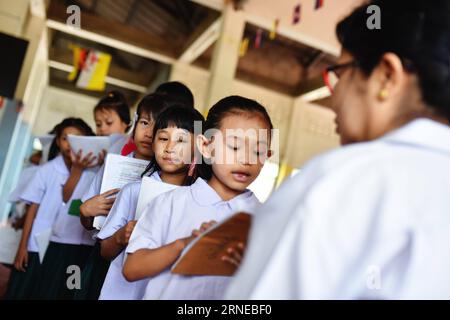 (160616) -- SAMUT SAKHON, June 16, 2016 -- Students line up to read Burmese text to their teacher at a school dedicated for the children of Myanmar migrant workers set inside Wat Tepnorrarat in Mahachai of Samut Sakhon Province, central Thailand, June 16, 2016. A seafood industry hub, Samut Sakhon is home for about 200,000 of the 2.4 million Myanmar migrant workers who seek job opportunities in Thailand. In order to provide decent education for the migrant workers children, local worker rights organizations have helped establish dedicated schools in four temples within the province. Students w Stock Photo