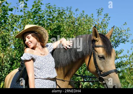 Ritratto di ragazza adolescente e cavallo in giorno di estate Foto Stock