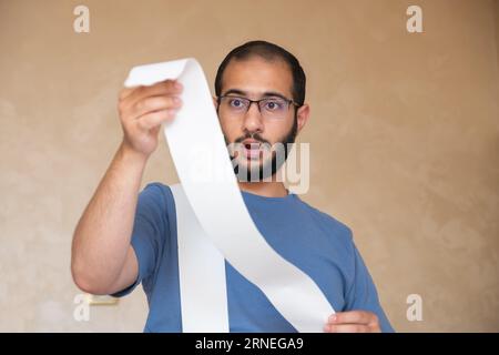 un uomo scioccato dall'ammontare delle bollette che deve pagare Foto Stock