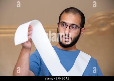 un uomo scioccato dall'ammontare delle bollette che deve pagare Foto Stock