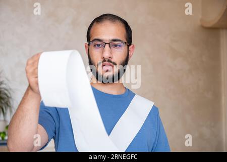 un uomo scioccato dall'ammontare delle bollette che deve pagare Foto Stock