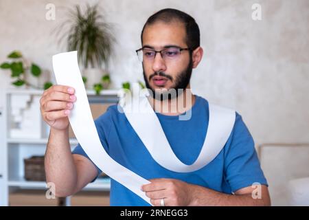 un uomo scioccato dall'ammontare delle bollette che deve pagare Foto Stock