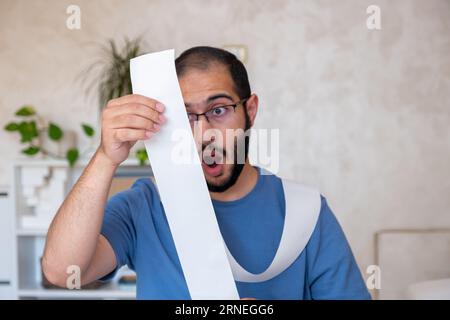 un uomo scioccato dall'ammontare delle bollette che deve pagare Foto Stock