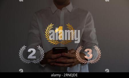 Podio per primo, secondo, terzo posto con laurel, numero e testo. Oro, argento e bronzo sul palco su sfondo rosso. Foto Stock