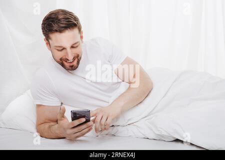 l'ossessione per il telefono cellulare costa sonno e tempo libero quando sdraiati a letto e dimentica il tempo Foto Stock