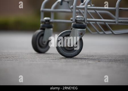 le ruote dei carrelli della spesa si stendono solitarie e si perdono all'aperto nel parcheggio Foto Stock