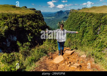 Donna escursionista che si diverte sulla scogliera nel parco Espraiado Canyon a Santa Catarina, Brasile. Foto Stock
